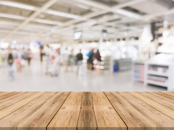 Träskiva tom tabell suddig köpcentrum bakgrund. Perspektiv brunt träbord oskärpa i varuhuset bakgrund - kan användas för visning eller montage dina produkter. Håna upp för produkt — Stockfoto