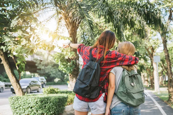 Couple of young Asian women standing along the street enjoying their city lifestyle on weekend waiting for outdoor activity. Young women and their city lifestyle. city lifestyle and outdoor concept.