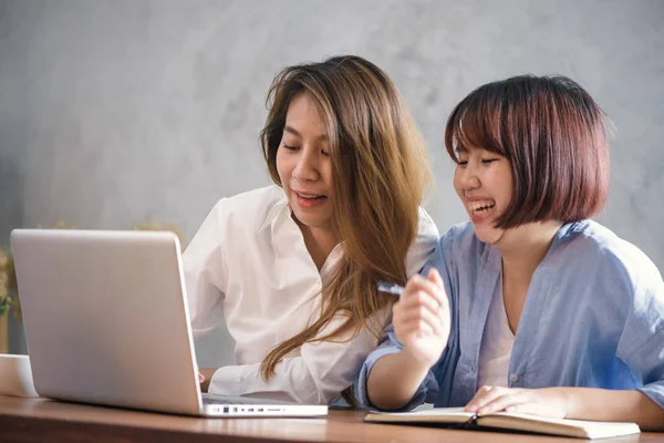 Duas jovens empresárias sentadas à mesa no café. Mulheres asiáticas usando laptop e xícara de café. Freelancer a trabalhar num café. Trabalhando fora do estilo de vida do escritório. Reunião individual . — Fotografia de Stock