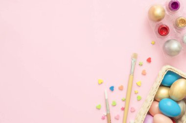 Pembe pastel renkli arka plan üzerinde boya fırçası ile pastel renkler bileşiminde düz yatıyordu üstten görünüm renkli Paskalya yortusu yumurta boyalı. Paskalya günü arka plan üstten görünüm kopya alanı ile.