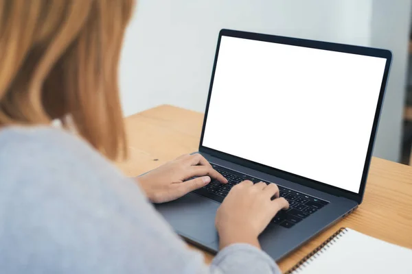 Jonge Aziatische vrouw die werkt met en typen op laptop met mock up leeg wit scherm terwijl thuis in werk kantoorruimte. Zakenvrouw thuiswerken via draagbare computer. Genieten van tijd thuis. — Stockfoto