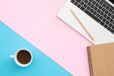 En az çalışma alanı - yaratıcı düz fotoğraf çalışma masası yatıyordu. Üstten Görünüm ofis büro dizüstü bilgisayar, dizüstü bilgisayarlar ve kahve fincanı pastel renk arka plan üzerinde. Kopya alanı, düz yatıyordu fotoğraf ile Üstten Görünüm.