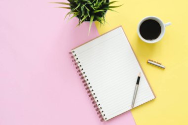Yaratıcı düz fotoğraf çalışma masası yatıyordu. Üstten Görünüm Ofis Masası sahte kadar dizüstü bilgisayarlar, bitki, pastel renkli arka plan üzerinde kahve Kupası ve kopya alanı ile. Kopya alanı, düz yatıyordu fotoğraf ile Üstten Görünüm.