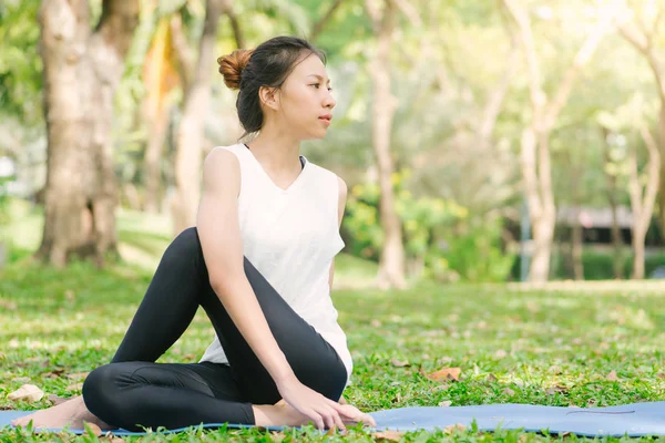 Young asian woman yoga outdoors keep calm and meditates while practicing yoga to explore the inner peace. Yoga and meditation have good benefits for health. Yoga Sport and Healthy lifestyle concept.