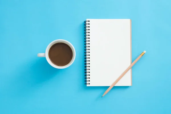 Office desk working space - Flat lay top view mockup of a working space with white blank notebook page, coffee cup and decoration on blue pastel background. Pastel blue color background space concept. — Stock Photo, Image