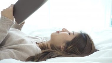 Evde rahat giyim kitap zevk okuma yatakta yalan zevk yaşam tarzı mutlu genç Asyalı kadın. Yaşam tarzı kadın kavramı rahatlatıcı.