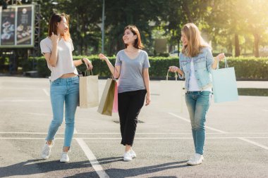 Grup genç Asyalı kadın açık bir pazarda alışveriş torbaları ellerinde ile alışveriş. Genç kadın sıcak güneş ışığı altında alışveriş torbasında marifetlerini göster. Grup açık alışveriş kavramı.