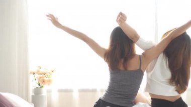 Sabah uyanma Asyalı kadınlar lezbiyen mutlu çift. Asyalı kızlar evde rahat yatak odasında germe yatakta oturuyor. Komik kadın arkadaşlar uyan sonra. LGBT lezbiyen çift birlikte kapalı kavramı.