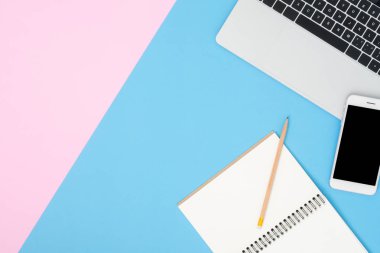 Ofis Resepsiyon çalışma alanı - düz üstten görünüm mockup fotoğraf çalışma alanı laptop ile alay smartphone ve boş defter pastel arka plan üzerinde yatıyordu. Mavi pembe renkli arka plan çalışma Resepsiyon kavramı.