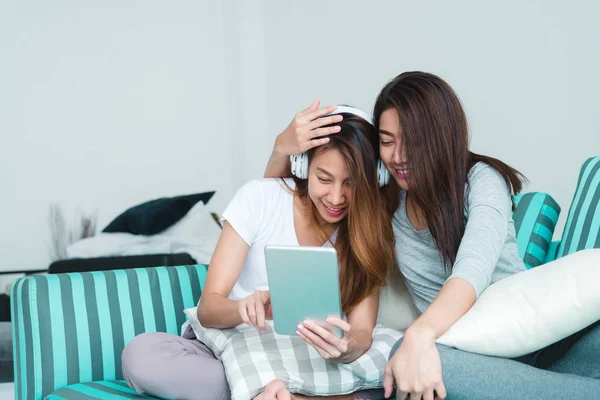 Vackra unga asiatiska kvinnor hbt-lesbisk lyckliga paret sitter på soffan att köpa online med tablett i vardagsrummet hemma. HBT-lesbisk par tillsammans inomhus koncept. Tillbringa trevliga tid hemma. — Stockfoto