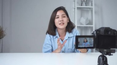 Asyalı kadın ya da güzellik blogger ile fırça ve video kaydı ve evde el sallayarak kamera gülümseyen mutlu. Güzellik videoblog bloglama insanlar kavramı. Dolly vurdu.