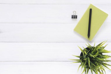 En az çalışma alanı - yaratıcı düz fotoğraf çalışma masası yatıyordu. Sahte defter ve kalem ve bitki ile beyaz ofis Resepsiyon ahşap masa arka plan. Kopya alanı, düz yatıyordu fotoğraf ile Üstten Görünüm
