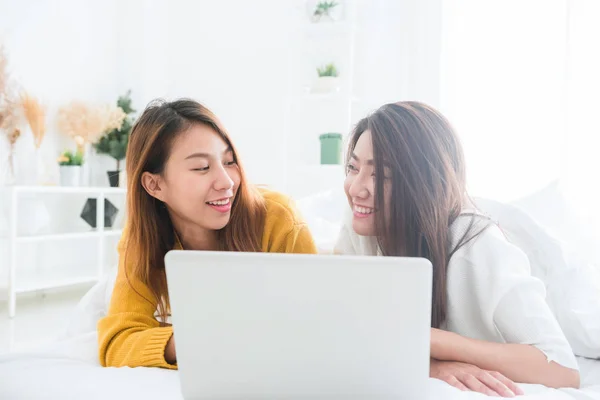 Belles jeunes femmes asiatiques LGBT lesbienne couple heureux assis sur le lit câlin et en utilisant un ordinateur portable ensemble chambre à coucher à la maison. LGBT couple lesbien ensemble concept intérieur. Passer du bon temps à la maison . — Photo