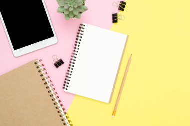 Ofis Masası adlı kullanıcının alanı - düz çalışma üstten görünüm fotoğraf çalışma alanı boş sahte tablet, ağaç bitki ve defter pastel zemin üzerine yatırın. Pastel pembe sarı renkli kopya alanı çalışma Resepsiyon kavramı.