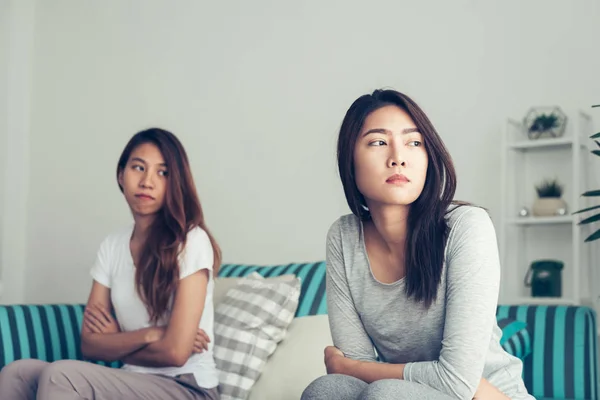 Young Asian lesbian couple argue and turn their back to each other in the period of sad in the bedroom. LGBT couple sulky to another in the bedroom with a sad mood. LGBT lover emotion concept. — Stock Photo, Image