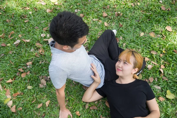 Genç Asyalı aşk çift parkta bir egzersiz sonrası birbirlerine duygu aşk sıcak öğleden sonra ile oynayarak sakin ol. Genç çift aşk parkta bir fikir verir. Çift açık egzersiz. — Stok fotoğraf