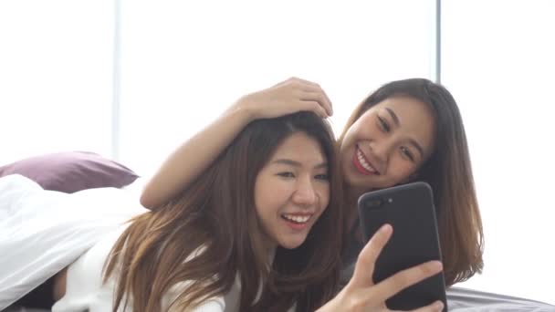 慢动作 美丽的年轻亚洲妇女 Lgbt 同性恋快乐夫妇坐在床上拥抱和使用电话自拍一起在家里的卧室 同性恋夫妇在一起室内概念 — 图库视频影像