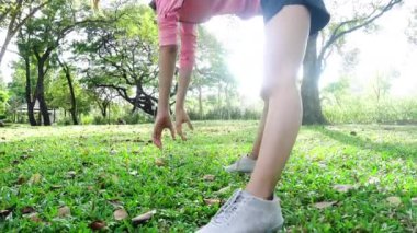 Parkta egzersiz sağlıklı genç Asyalı kadın. Genç kadının sabah eğitim egzersiz yapması uygun. Çalışan bir egzersiz yaptıktan sonra parkta uzanan genç mutlu Asyalı kadın. Egzersiz açık kavramı.