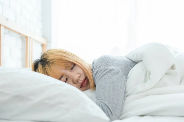 Beautiful young Asian woman sleeping in bed in the morning. Attractive asian girl use bedtime in her comfortable bedroom. Relaxation bedroom. Iifestyle asia woman at home concept. — Stock Photo, Image