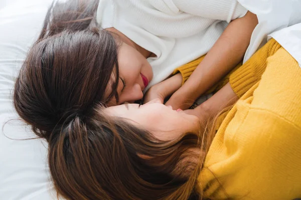 Beautiful young asian women LGBT lesbian happy couple hugging and smiling while lying together in bed under blanket at home. Funny women after wake up. LGBT lesbian couple together indoors concept. — Stock Photo, Image