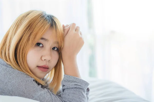 Potret wanita Asia muda yang cantik di tempat tidur di rumah di pagi hari. Wanita Asia yang ceria mengenakan sweater yang nyaman dan tersenyum di tempat tidurnya. Ruang santai. gaya hidup asia wanita di konsep rumah . — Stok Foto