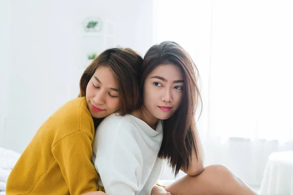 Belles jeunes femmes asiatiques LGBT lesbienne couple heureux assis sur le lit étreignant et souriant ensemble dans la chambre à coucher à la maison. LGBT couple lesbien ensemble concept intérieur. Passer du bon temps à la maison . — Photo