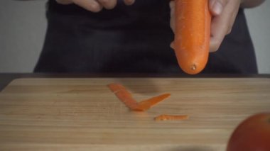 Yavaş hareket - sağlıklı yemek yapma ve mutfakta kesme tahtası üzerinde havuç doğrama kadının yakın.