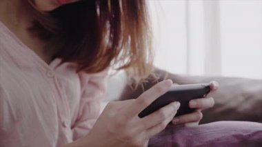 Mutlu Asyalı kadınlar akıllı telefon sabah yatakta kullanıyorsunuz. Asyalı kadın yatakta smartphone ile sosyal uygulamalar kontrol. Gülümseyen kadın evde cep telefonu ile net sörf. Telefon bağımlısı kavramı. 