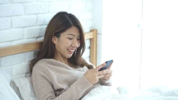 Les Femmes Asiatiques Heureuses Utilisent Téléphone Intelligent Sur Lit Matin — Video