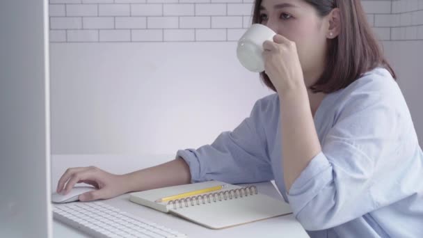집에서 거실에 따뜻한 커피를 마시는 즐기고 노트북에 집에서 즐기는 그녀의 — 비디오