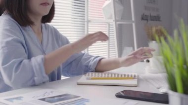 Evde oturma odasında otururken dizüstü bilgisayarda çalışma güzel genç gülümseyen Asyalı kadın. Ev ofisinde çalışan Asya iş kadın. Evde zaman zevk.