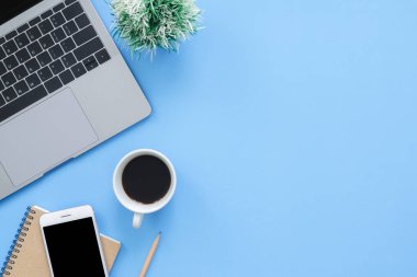 Ofis Resepsiyon çalışma alanı - düz üstten görünüm mockup fotoğraf çalışma alanı laptop, smartphone, kahve ve defter pastel mavi zemin üzerine yatırın. Pastel mavi renk arka plan çalışma Resepsiyon kavramı