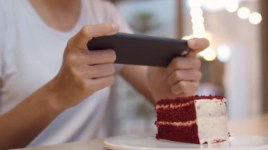 Blogger Asyalı arkadaş canlısı kadın etkileyicisi gece kafeteryasında pasta yiyor. Güzel genç bayan, rahatla. Teknoloji cep telefonu kullanarak rahatla. Üniversite kampüsünde sosyal medyada yemek yüklerken fotoğrafını çek..