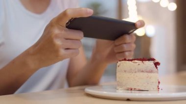 Blogger Asyalı arkadaş canlısı kadın etkileyicisi gece kafeteryasında pasta yiyor. Güzel genç bayan, rahatla. Teknoloji cep telefonu kullanarak rahatla. Üniversite kampüsünde sosyal medyada yemek yüklerken fotoğrafını çek..
