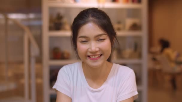 肖像アジア系中国人の女性が大学の図書館で笑顔を感じている 若いです学部生ティーン女の子リラックスおもちゃの笑顔見ますへカメラで大学キャンパス残業時の夜のコンセプト — ストック動画
