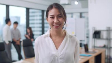 Başarılı yönetici iş kadınının portresi. Gündelik kıyafetlerle kameraya bakıp gülümsüyor. Modern ofis işyerinde kollarını kavuşturuyor. Genç Asyalı bayan çağdaş toplantı odasında duruyor..