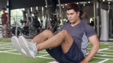Egzersiz yaparken yalan söyleyen yakışıklı genç Asyalı spor salonunda yağ yakma egzersizi yapıyor. Altılı paketli sporcu, sporcu eğlence aktivitesi, fonksiyonel eğitim, sağlıklı yaşam tarzı konsepti.