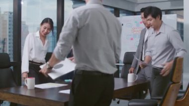 Milenyum Asyalı iş adamları ve iş kadınları yeni evrak projeleri hakkında fikir alışverişinde bulunuyorlar. İş arkadaşları birlikte çalışıyorlar. Başarı stratejisi planlıyorlar..