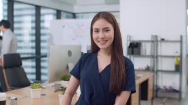 Başarılı yönetici iş kadınının portresi. Gündelik kıyafetlerle kameraya bakıp gülümsüyor. Modern ofis işyerinde kollarını kavuşturuyor. Genç Asyalı bayan çağdaş toplantı odasında duruyor..