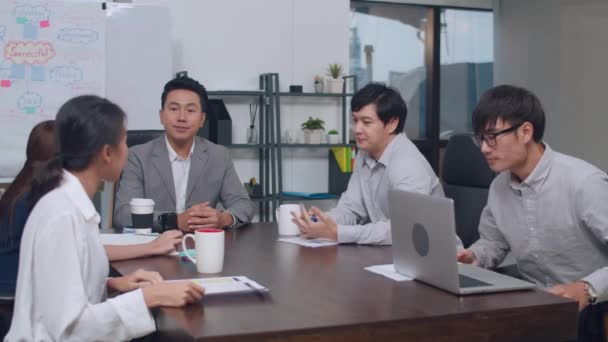 千年のアジアのビジネスマンとビジネス女性が新しい書類作成プロジェクトの同僚についてブレインストーミングのアイデアを満たす一緒に成功戦略を計画作業小さな現代の夜のオフィスでチームワークをお楽しみください — ストック動画