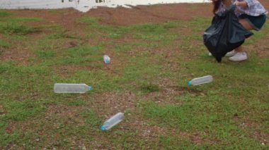 Genç Asyalı aktivistler plajda plastik atık topluyor. Koreli kadın gönüllüler doğayı temizlemeye ve çöpleri toplamaya yardım ediyor. Çevre koruma kirliliği sorunları hakkında kavram.