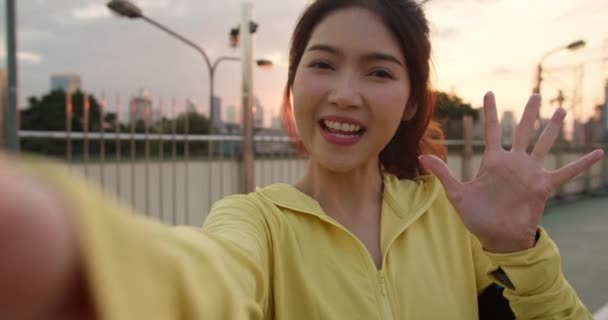 有魅力的年轻亚洲运动员在城市锻炼的同时 通过社交媒体在网上直播视频 影响了节目主持人女士 早上穿运动服在街上的女运动员 — 图库视频影像