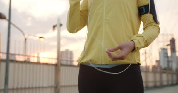 아름답고 아시아 선수가 환경에서 달리는 스마트폰으로 음악을 운동을 위에서 스포츠 — 비디오