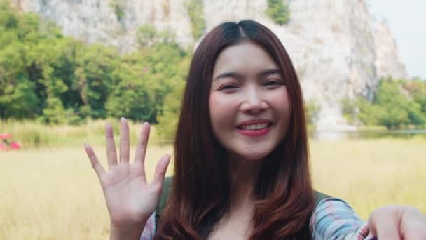快乐的年轻旅行家亚洲女士背着背包 在高山湖畔的社交媒体上通过电话上传直播视频 韩国女孩快乐地享受假日旅行 生活方式的旅行和放松 — 图库视频影像