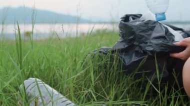 Genç Asyalı aktivistler ormanda plastik atık topluyor. Koreli kadın gönüllüler doğayı temizlemeye ve çöpleri toplamaya yardım ediyor. Çevre koruma kirliliği sorunları hakkında kavram.