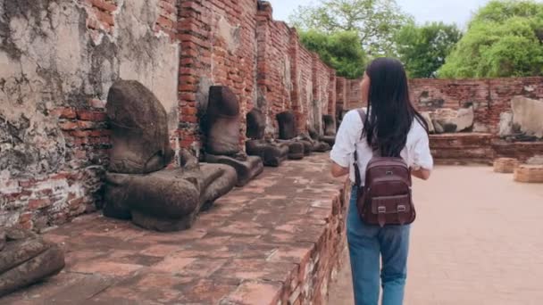 タイのアユタヤで休暇を過ごす旅行者アジアの女性 日本のバックパッカーの女性は 伝統的な都市の素晴らしいランドマークで彼女の旅をお楽しみください ライフスタイルの女性旅行休日のコンセプト — ストック動画