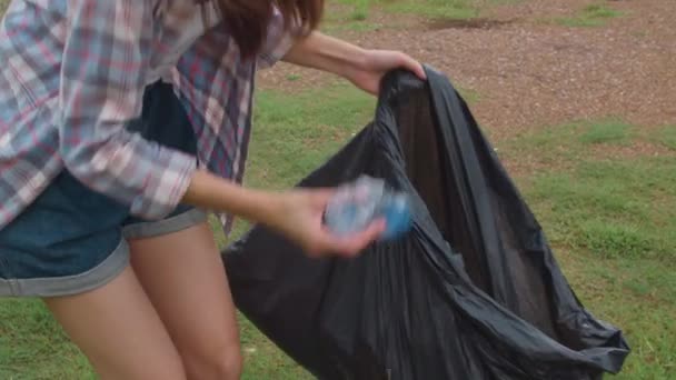 快乐的年轻的亚洲积极分子在海滩上收集塑料垃圾 韩国女性志愿者帮助保持自然清洁和捡垃圾 环境保护及污染问题的概念 — 图库视频影像
