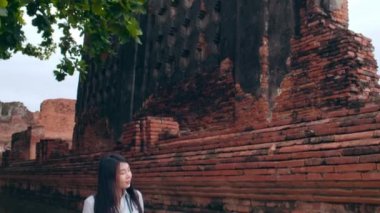 Gezgin Asyalı kadın, tatilini Ayutthaya, Tayland 'da geçiriyor. Japon sırt çantalı kadın, geleneksel kentteki inanılmaz şehir simgesinde yolculuğunun tadını çıkarıyor. Yaşam tarzı kadınlar tatil konsepti ile seyahat eder.