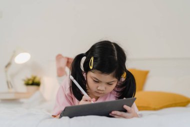 Genç Asyalı kız evde resim çiziyor. Asyalı kadın Japon çocuk rahatla dinlen eğlen çizim defterine çizgi film çiz yatağa yatmadan önce, yatak odasında rahatla ve sakinleş gece konseptinde.