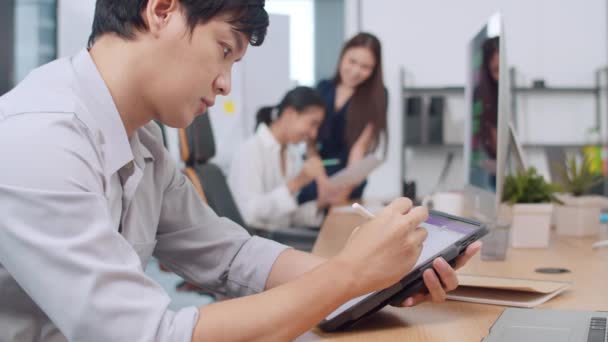成功的亚洲行政总裁年轻商人智能休闲装的绘制 书写和使用带有数字平板电脑思维的钢笔在现代办公室中的灵感搜索工作过程 — 图库视频影像